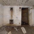 Ve stěně se vstupními dveřmi je i prostup do komína a vymetací otvor na saze, na stropě se odhaluje nedostatečně kytá výztuž